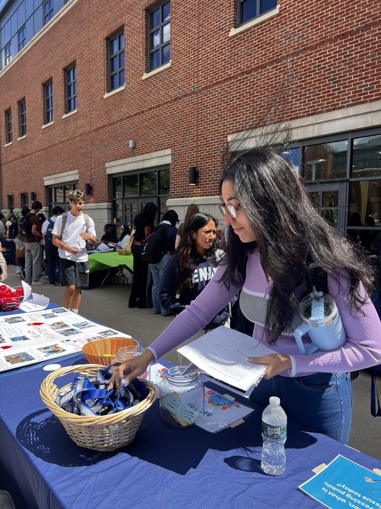 Student reaches into bowl at UConn Waterbury table