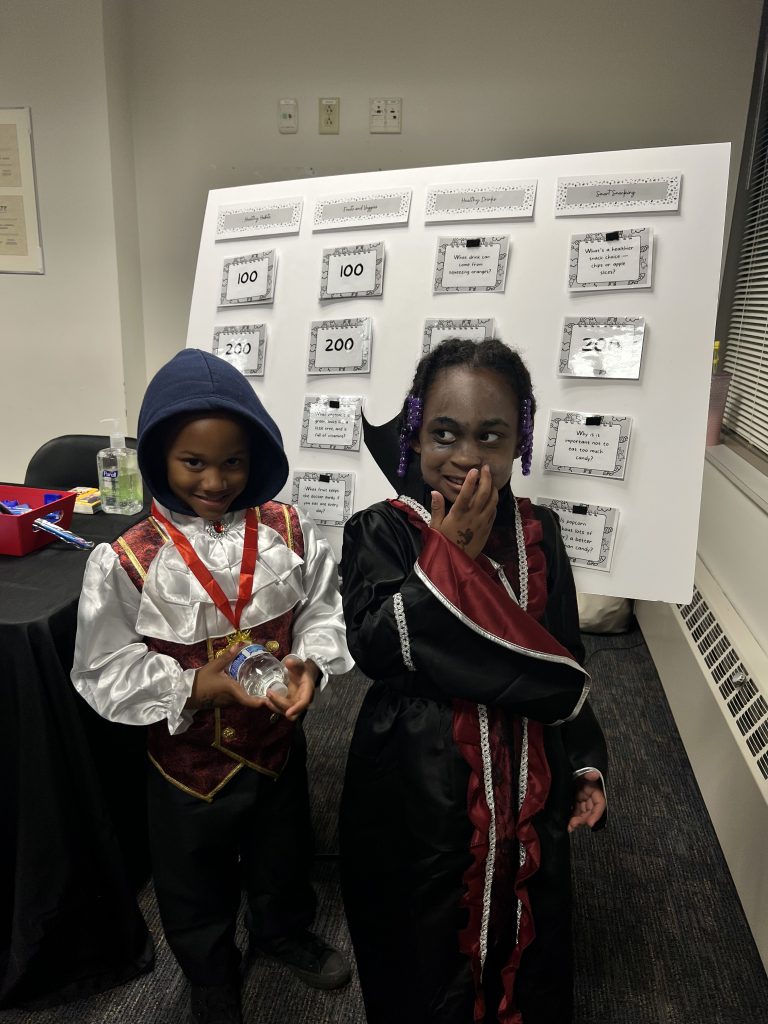 little kids in front of jeopardy signs